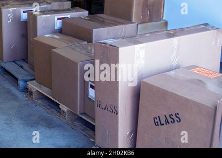 Wooden pallets hold boxes of many shapes and sizes, ready to be shipped world wide from a local factory Stock Photo