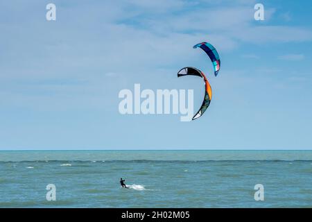 St Joseph MI USA, Sept 26, 2021; a kite surfer enjoys Lake Michigan, while a second kite surfer comes up swiftly behind him Stock Photo