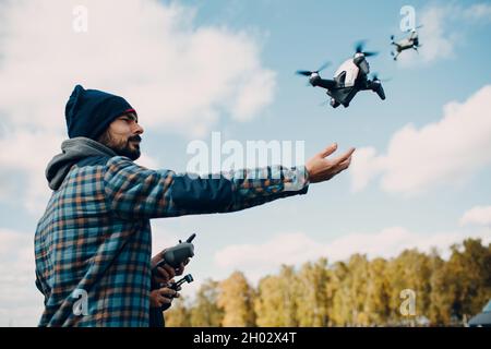 Man pilot Launches quadcopter FPV drone from hand to sky flight Stock Photo