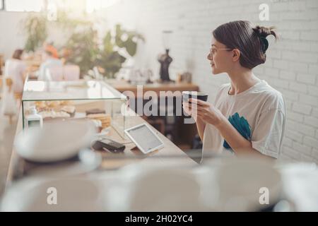 Nice young woman drinking coffee in coffee shop Stock Photo