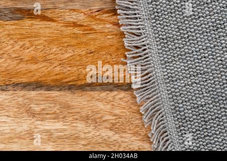 Jute cotton rough woven gray mat texture on a wooden textured rustic surface. Copy space Stock Photo