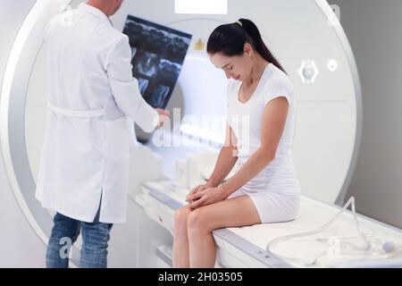 Doctor examines MRI image in front of patient closeup Stock Photo