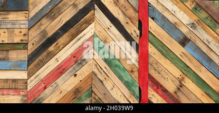 Highly unique abstract geometric patterns made from recycled cut timber palettes arranged in diagonal stripes. Multi colored textural upcycled planks Stock Photo