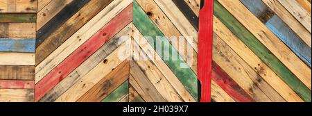 Highly unique abstract geometric patterns made from recycled cut timber palettes arranged in diagonal stripes. Multi colored textural upcycled planks Stock Photo