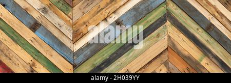 Highly unique abstract geometric patterns made from recycled cut timber palettes arranged in diagonal stripes. Multi colored textural upcycled planks Stock Photo