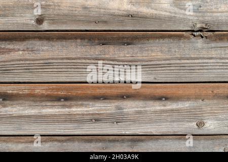 An old wooden wall. Weathered, cracked boards nailed down with rusty nails. Natural background Stock Photo