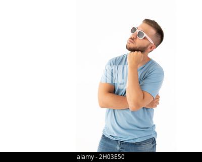 Pensive man looking up with a sunglasses on a white background Stock Photo
