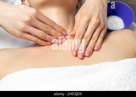 Close-up beautician doctor hand making anti-age procedure, mask and peeling for young attractive female client at beauty clinic. Cosmetologist Stock Photo