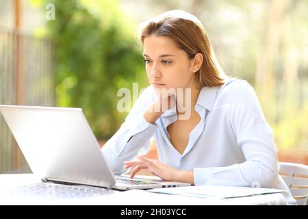 Serious businesswoman working online with laptop in terrace Stock Photo