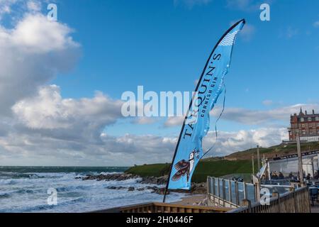 An advertising banner for Tarquins Cornish Gin fluttering in the wind at Fistral Beach Bar in Newquay in Cornwall. Stock Photo