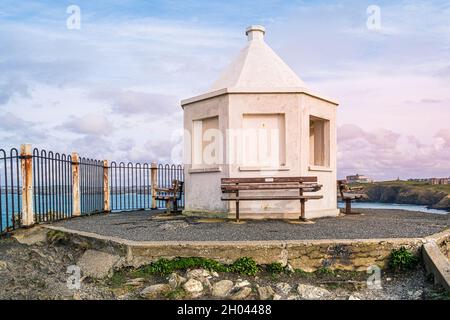 Evening light over the small white octagonal Old Coastguard Lookout Station on the summit of Towan Head in Newquay in Cornwall. Stock Photo