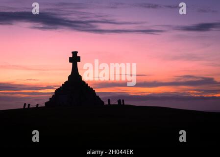 The imposing Newquay War memorial siulhouetted against a dramatic sunset in Cornwall. Stock Photo