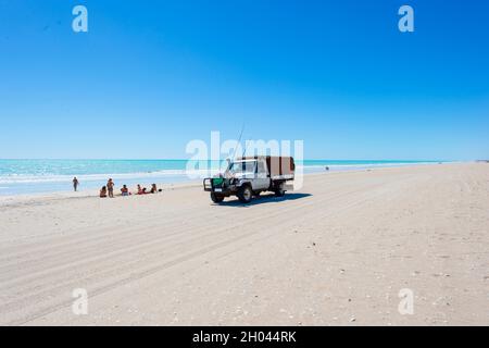 Family sat on the beach next to a ute with fishing rods, Eighty Mile Beach, Western Australia, WA, Australia Stock Photo