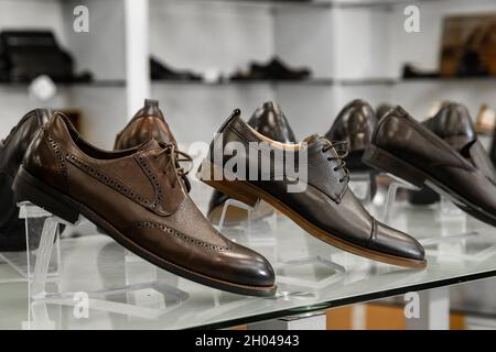 Men's brown and black summer shoes are at the forefront of the runways in the clothing store. Stock Photo