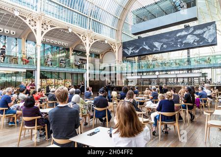 People watching an opera performance at Paul Hamlyn Hall (Floral Hall) at the Royal Opera House, Covent Garden, London, UK Stock Photo