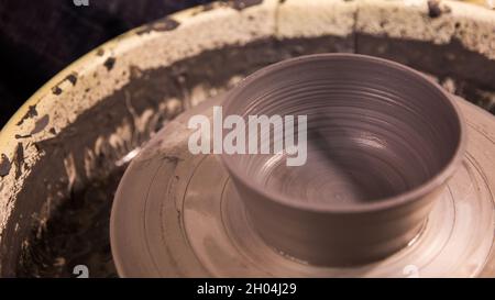 Vase from fresh clay turn twirl potters wheel. Sculptor in workshop makes jug out of clay closeup. Master crock. Potters work close-up. Handmade. Craf Stock Photo