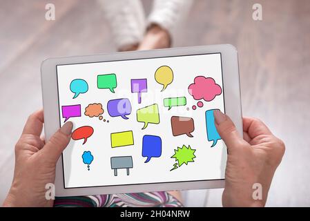 Communication concept shown on a tablet held by a woman Stock Photo