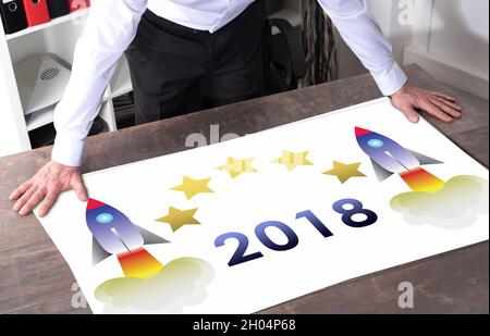 Man watching a new year 2018 concept placed on a desk