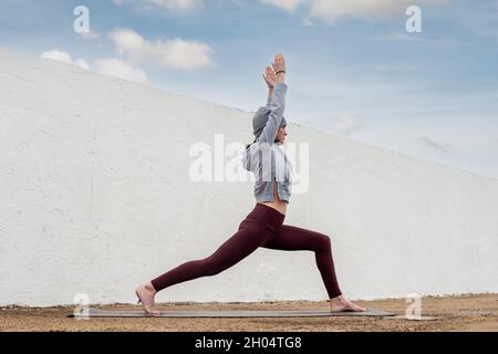 Sporty woman practicing yoga and keeping fit outside in the autumn. Stock Photo