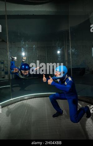 A man teaches a boy to fly in a wind tunnel. Stock Photo