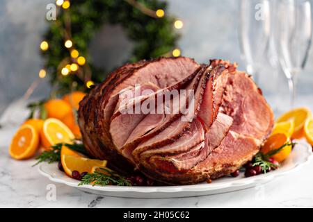 Spiral sliced Christmas ham with orange honey glaze on a serving plate Stock Photo