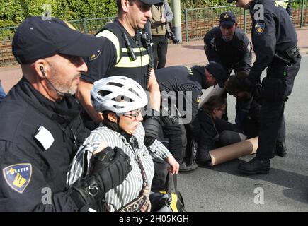 The Hague, Netherlands. 11th Oct, 2021. Dutch anti-riot police officers arrest the Extinction Rebellion environment activists block the street during protest near central station on October 11, 2021 in The Hague, Netherlands. Environmental protestors of Extinction Rebellion make a demonstration drawing attention, all over the world people are being killed by famine and natural disasters caused by the climate and ecological emergency ahead of the upcoming COP26 summit in Glasgow in November. (Photo by Paulo Amorim/Sipa USA) Credit: Sipa USA/Alamy Live News Stock Photo