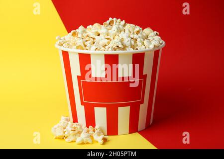 Striped paper cup with popcorn on two tone background. Stock Photo