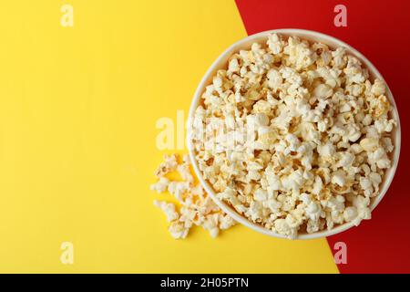 Striped paper cup with popcorn on two tone background. Stock Photo