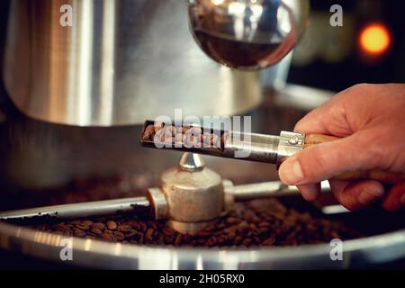 Close up of a worker in coffee roasting process in factory Stock Photo
