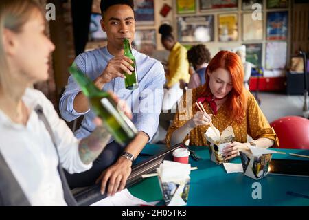 group of multiethnic people having break at work, eating, drinking, socializing Stock Photo