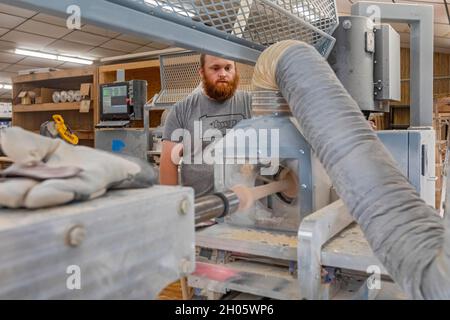 Brookville, Pennsylvania - Kevin Gnacinski makes a baseball bat on a lathe at BWP Bats. The company makes bats for both professional and amateur playe Stock Photo