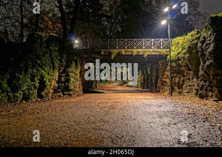 Night Walking in a dark silent deserted public park on a muddy path after the rainfall - Indro Montanelli Gardens - Milan - Italy Stock Photo