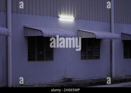 The scenery of lights is turned on as night falls at a hall building above the window awning. Maghrib time at Kuantan Malaysia. Stock Photo