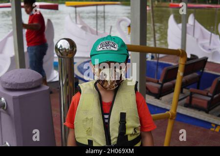 A kid wearing a safety life jacket before being released to play family paddle boat at City Lake Park Kuantan Malaysia. Stock Photo