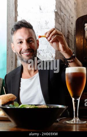 A young bearded man having lunch in an urban pub Stock Photo