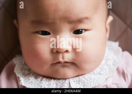 Close-up of Asian cute newborn baby looking at camera Stock Photo