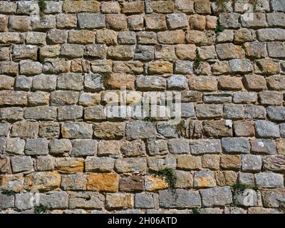 Rows of old stone blocks in an ancient wall. Taken on a sunny day. Stock Photo