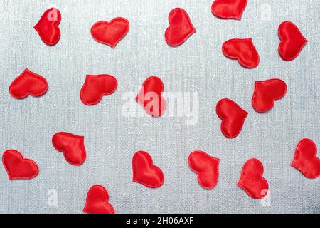 red hearts scattered on a silver background Stock Photo