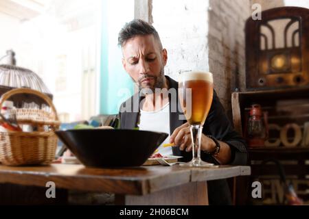 A young bearded man having lunch in an urban pub Stock Photo