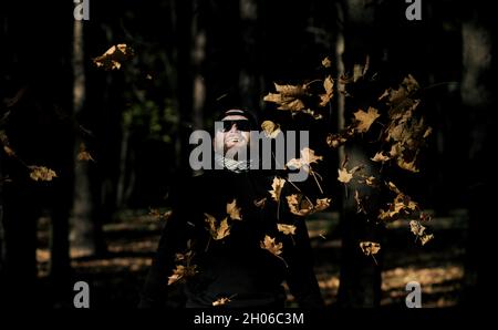 Happy man throwing autumn leaves in air Stock Photo