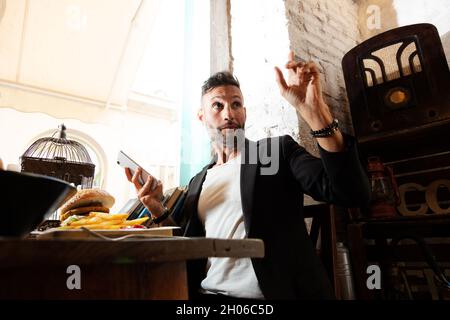 A young bearded man having lunch in an urban pub Stock Photo