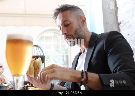A young bearded man having lunch in an urban pub Stock Photo