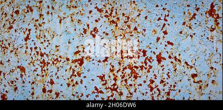 The texture of old peeling paint and bleached rust on a metal plate. Stock Photo