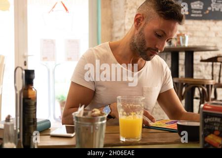 A young bearded man having lunch in an urban pub Stock Photo