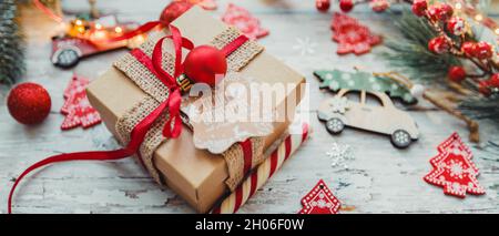 Christmas gift with a red ribbon on a wooden background with snowflakes. selective focus Stock Photo