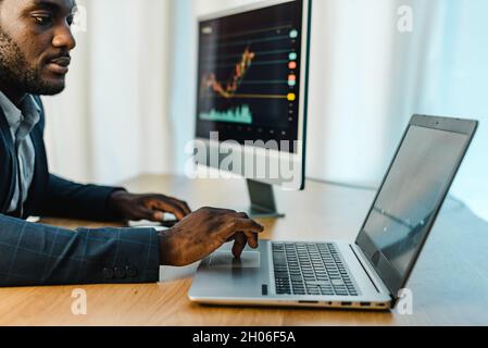 Focused male trader using laptop Stock Photo