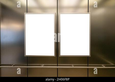 Mock up. Two vertical poster media template frame hanging on the wall in elevator lift Stock Photo