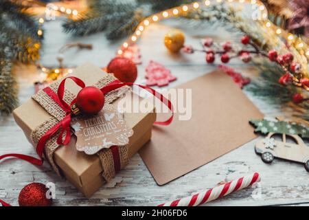 Christmas gift with a red ribbon on a wooden background with snowflakes. selective focus Stock Photo