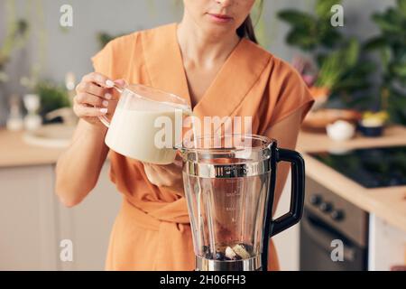 close up of woman hand pouring milk to blender Stock Photo - Alamy