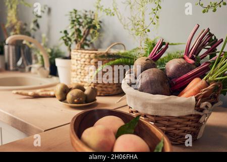 Bowl and basket with fresh fruit and vegetables on kitchen table for preparing smoothie Stock Photo